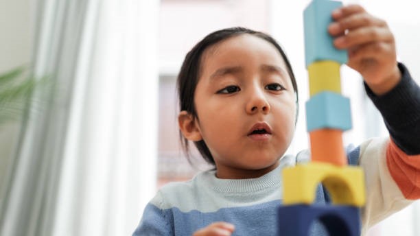 Child concentrating on building a brick tower