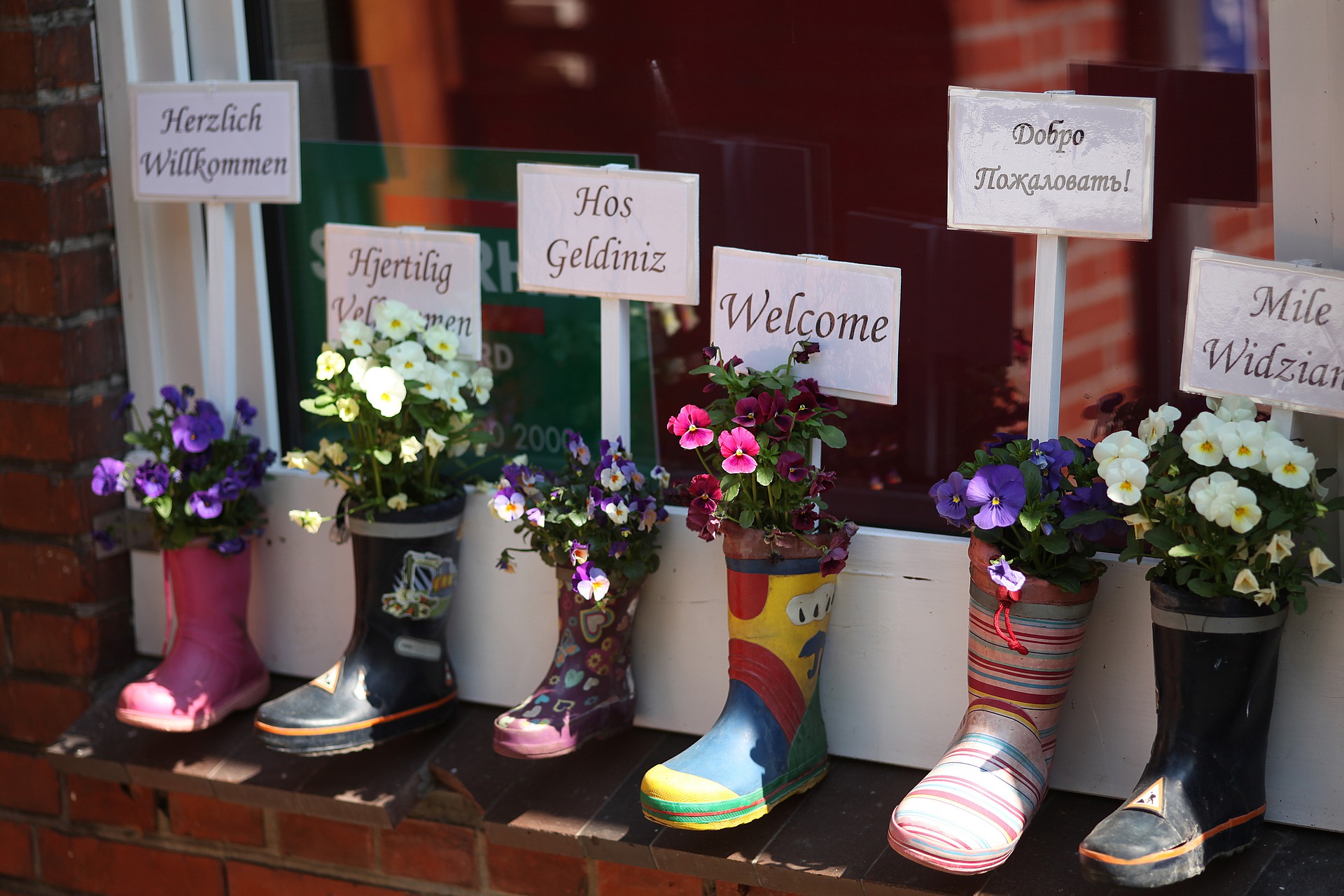 Decorative boots, containing the word 'Welcome' written in many different languages